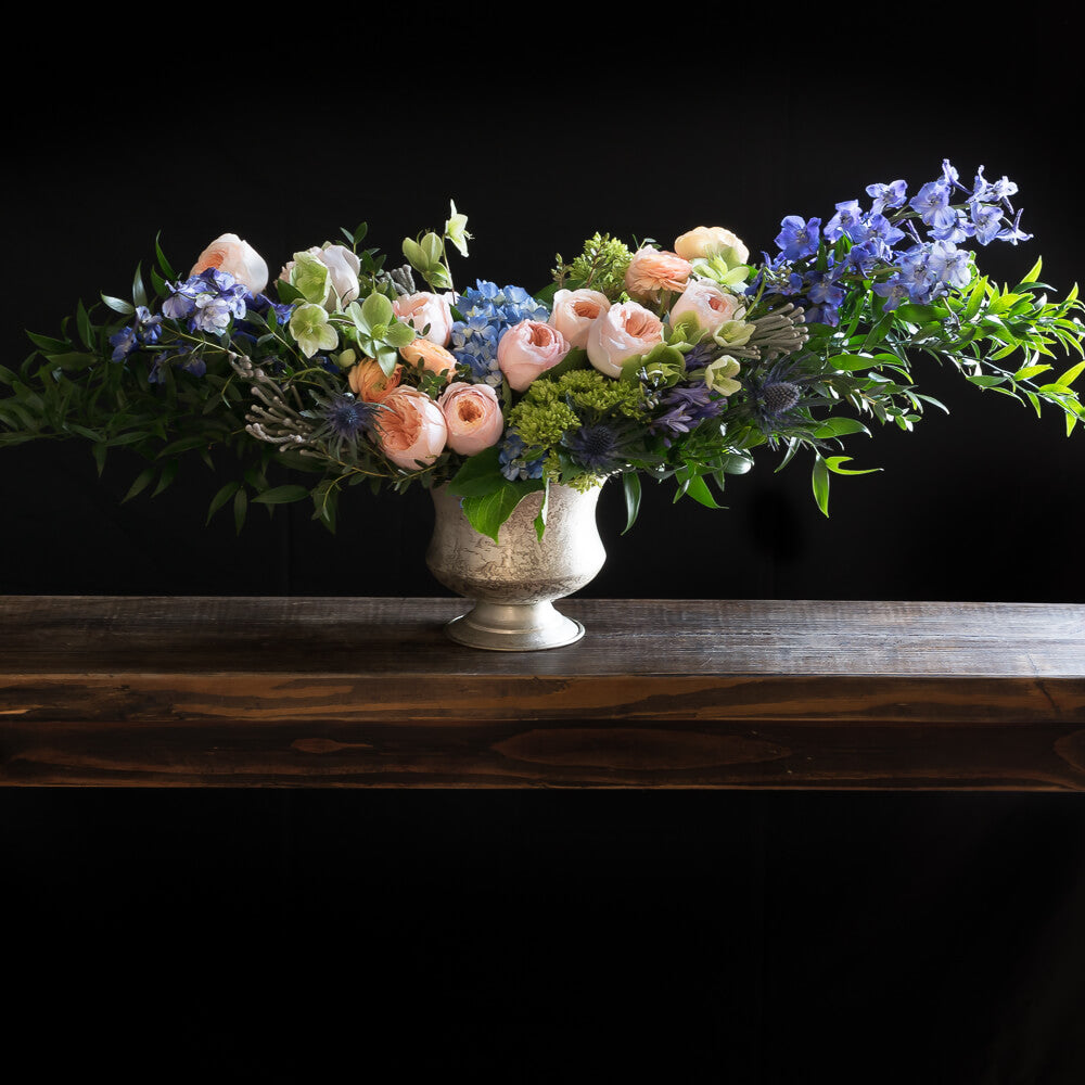Boutique Luxe floral arrangement with blush roses, blue flowers, hellebores, hydrangeas,