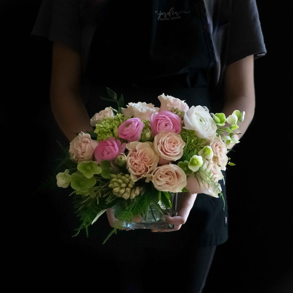 Cool unique boutique floral arrangement with light pink roses, light pink ranunculus, and hyacinths.