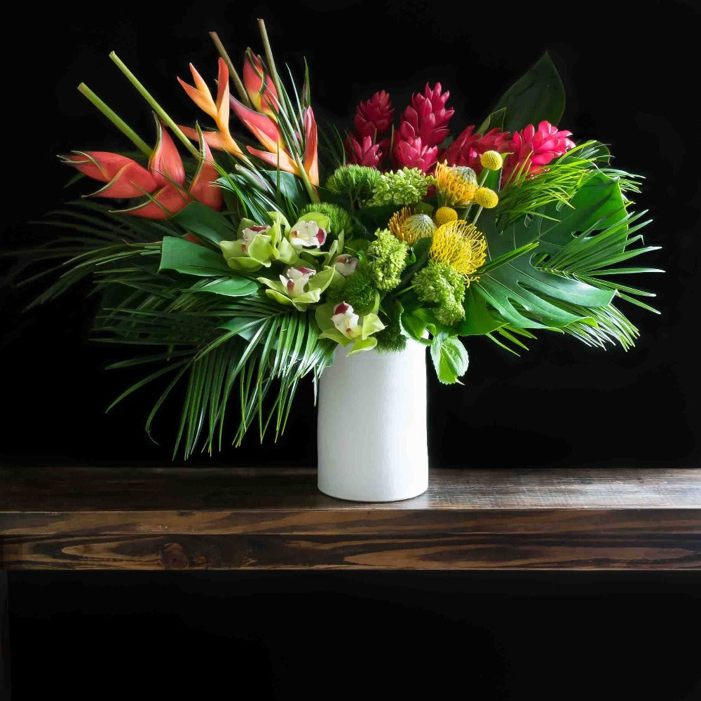 Tall tropical floral arrangement with burgundy, yellow, and red tropical flowers