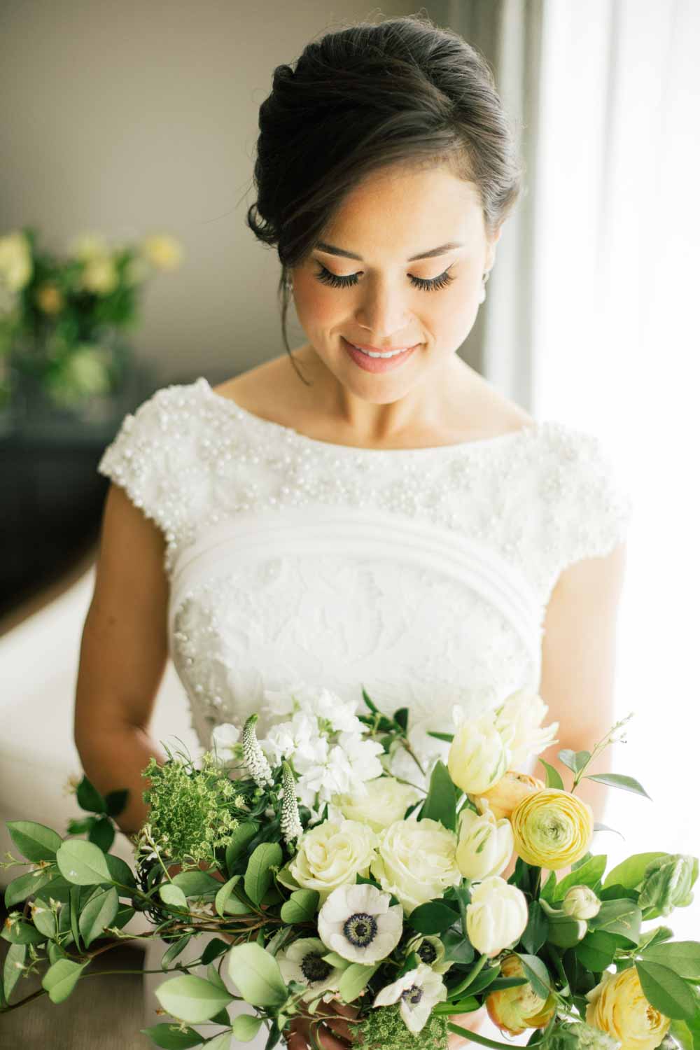 Anastasiia Photography | Bride with wedding bouquet made with white roses, white anemonies, white flowers