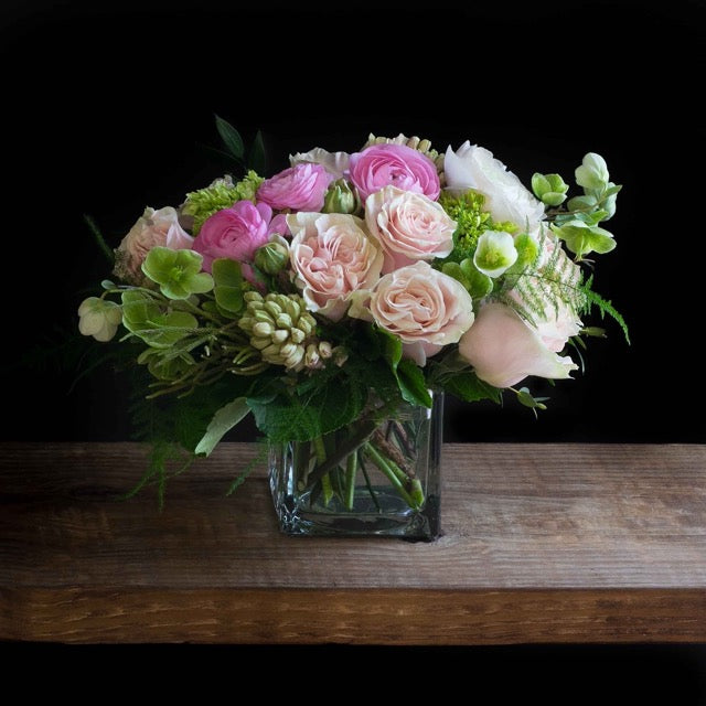 Beautiful unique boutique floral arrangement with light pink roses, fragrant garden roses, light pink ranunculus, and hyacinths.