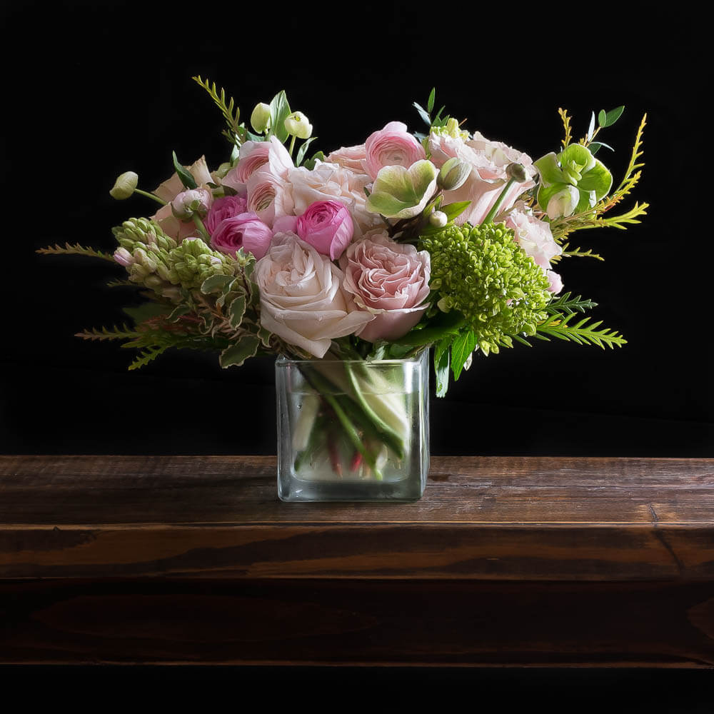 Beautiful unique boutique floral arrangement with light pink roses, fragrant garden roses, light pink ranunculus, and hyacinths.