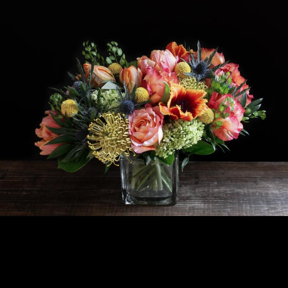 Beautiful unique boutique floral design of orange garden roses, yellow tulips, and orange tulips