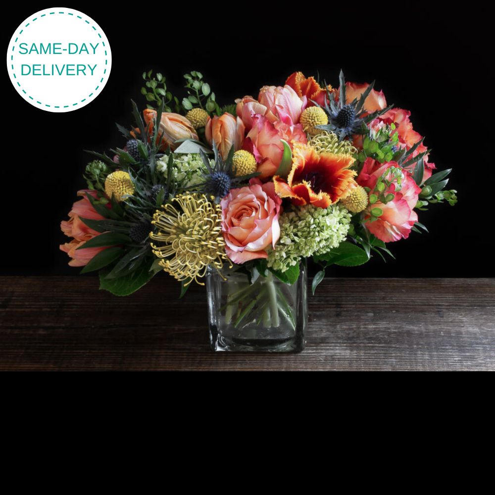 Beautiful unique boutique floral design of orange garden roses, yellow tulips, and orange tulips