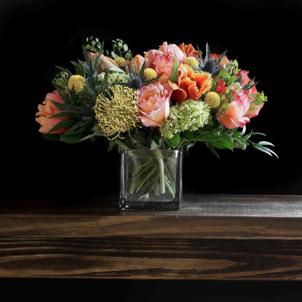 Beautiful unique boutique floral design of orange garden roses, yellow tulips, and orange tulips