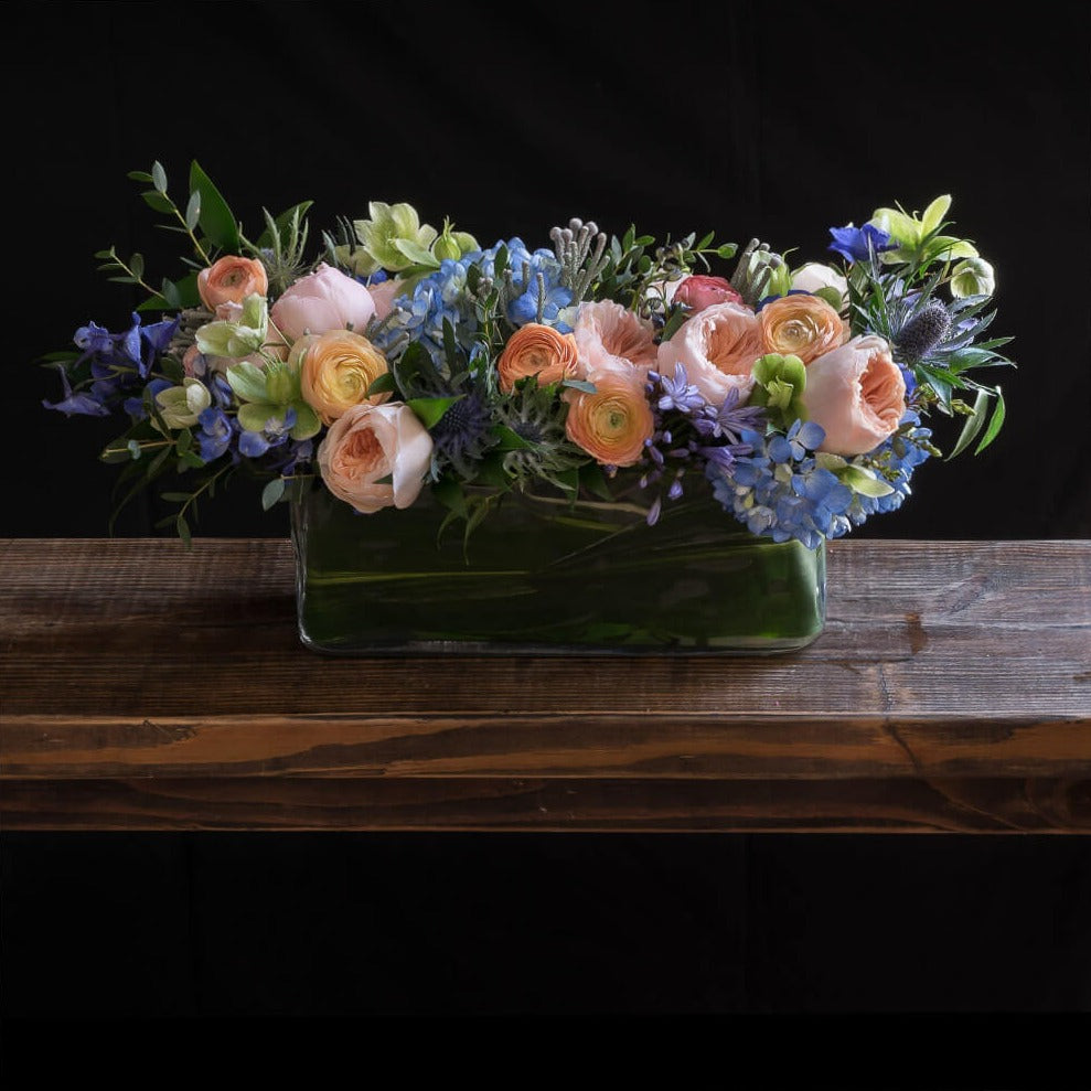 Beautiful floral arrangement with blush roses, blue flowers, hellebores, hydrangeas