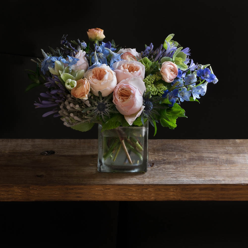 Beautiful floral arrangement with blush roses, blue flowers, hellebores, hydrangeas