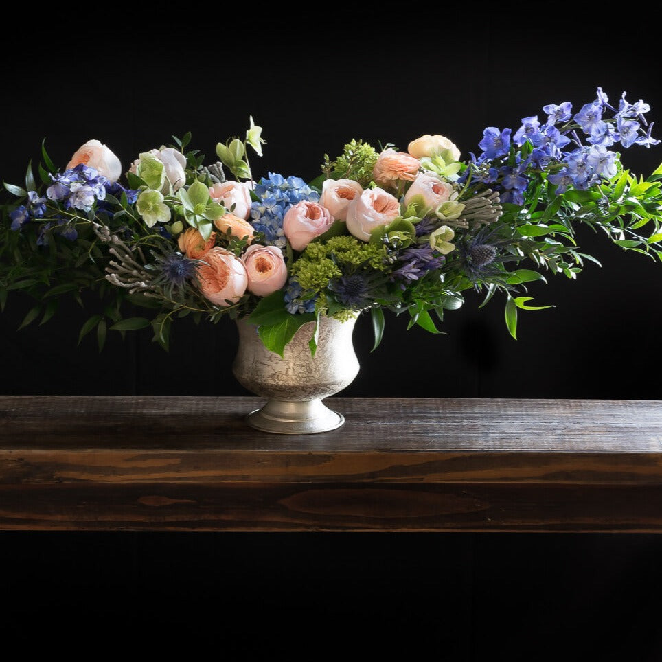 Boutique Luxe floral arrangement with blush roses, blue flowers, hellebores, hydrangeas,