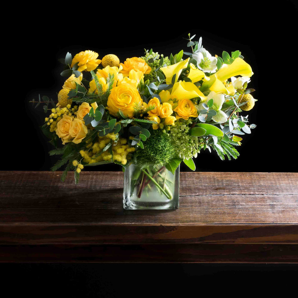 
Beautiful boutique flower arrangement - yellow ranunculus, yellow calla lilies, light yellow spray roses, and mini green hydrangeas.