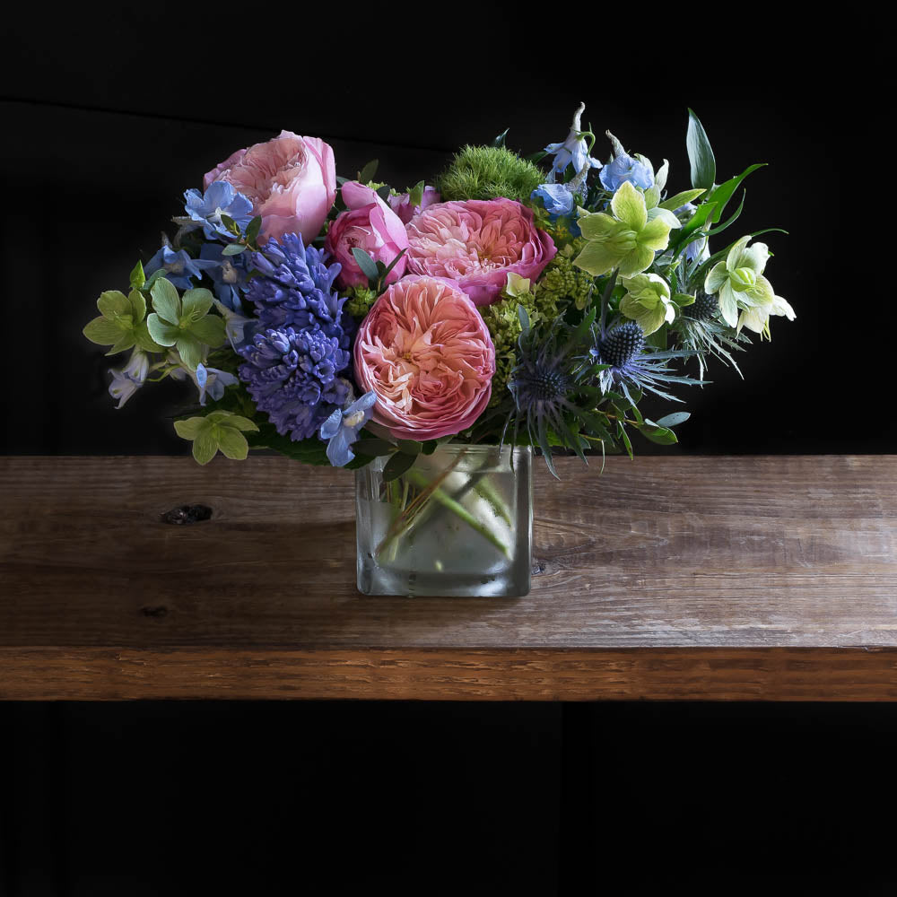 Unique floral arrangement with light pink fragrant David Austin garden roses, light pink small roses, blue hyacinths, and mini green hydrangeas.