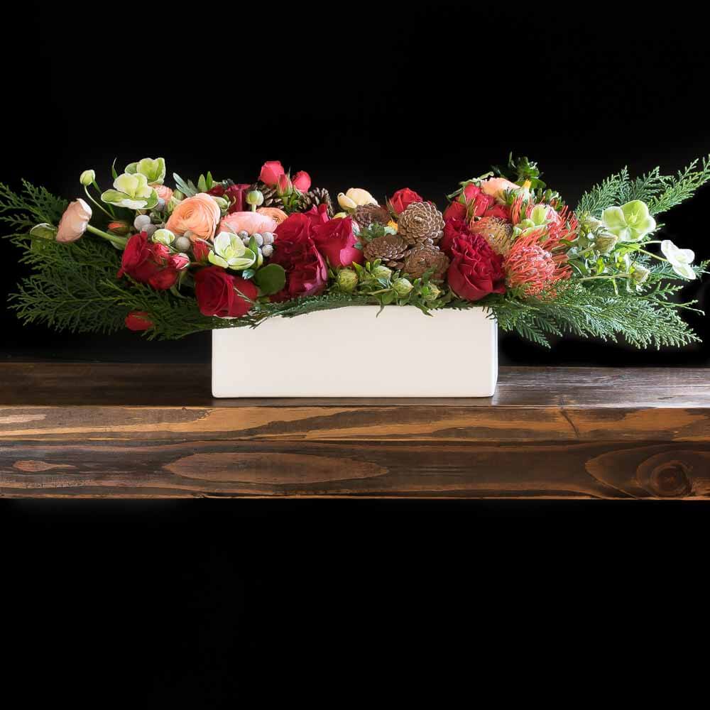 Holidays, Christmas centerpiece floral arrangement with red roses, cones, and light pink proteas.