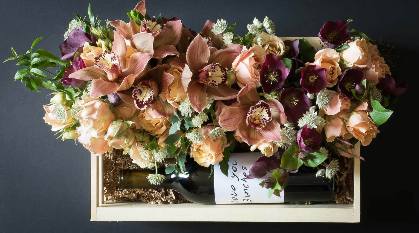 Floral gift basket box with beautiful boutique flowers as cymbidium orchids, roses, and helebores