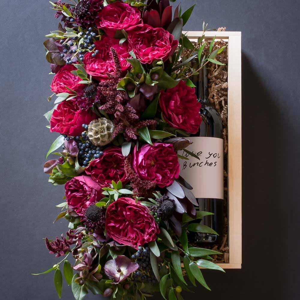 Jardin Floral gift box with red roses, burgundy flowers, and red organic wine