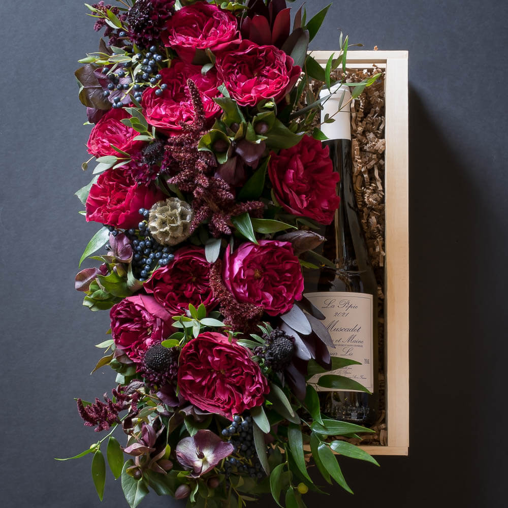 Jardin Floral gift box with red roses, burgundy flowers, and white organic wine