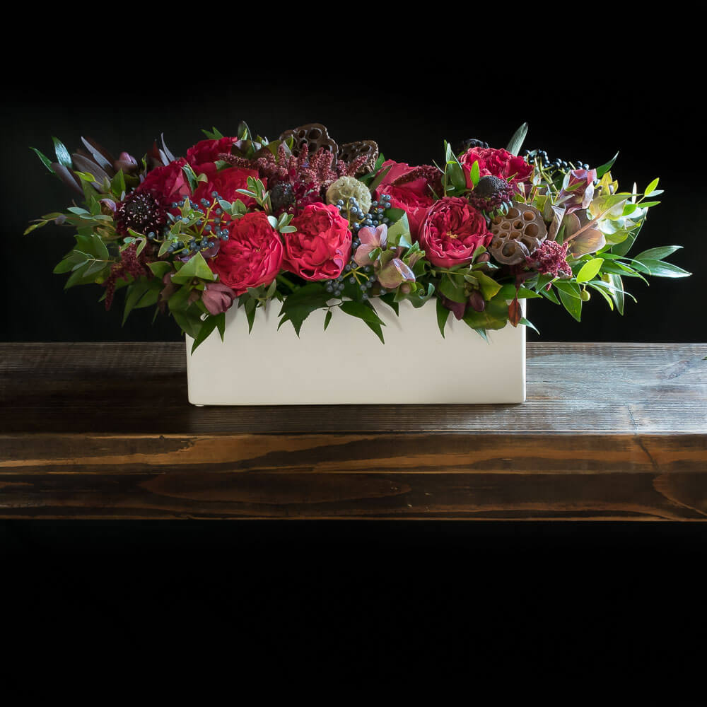 Christmas, holiday centerpiece floral arrangement of red roses, light pink proteas.