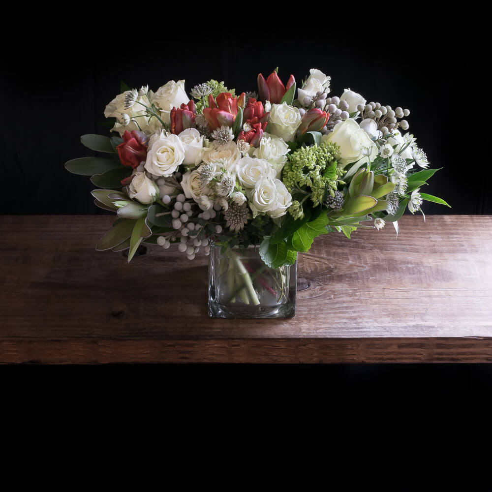 Jardin boutique floral arrangement for holiday, Christmas, with white roses, red tulips.