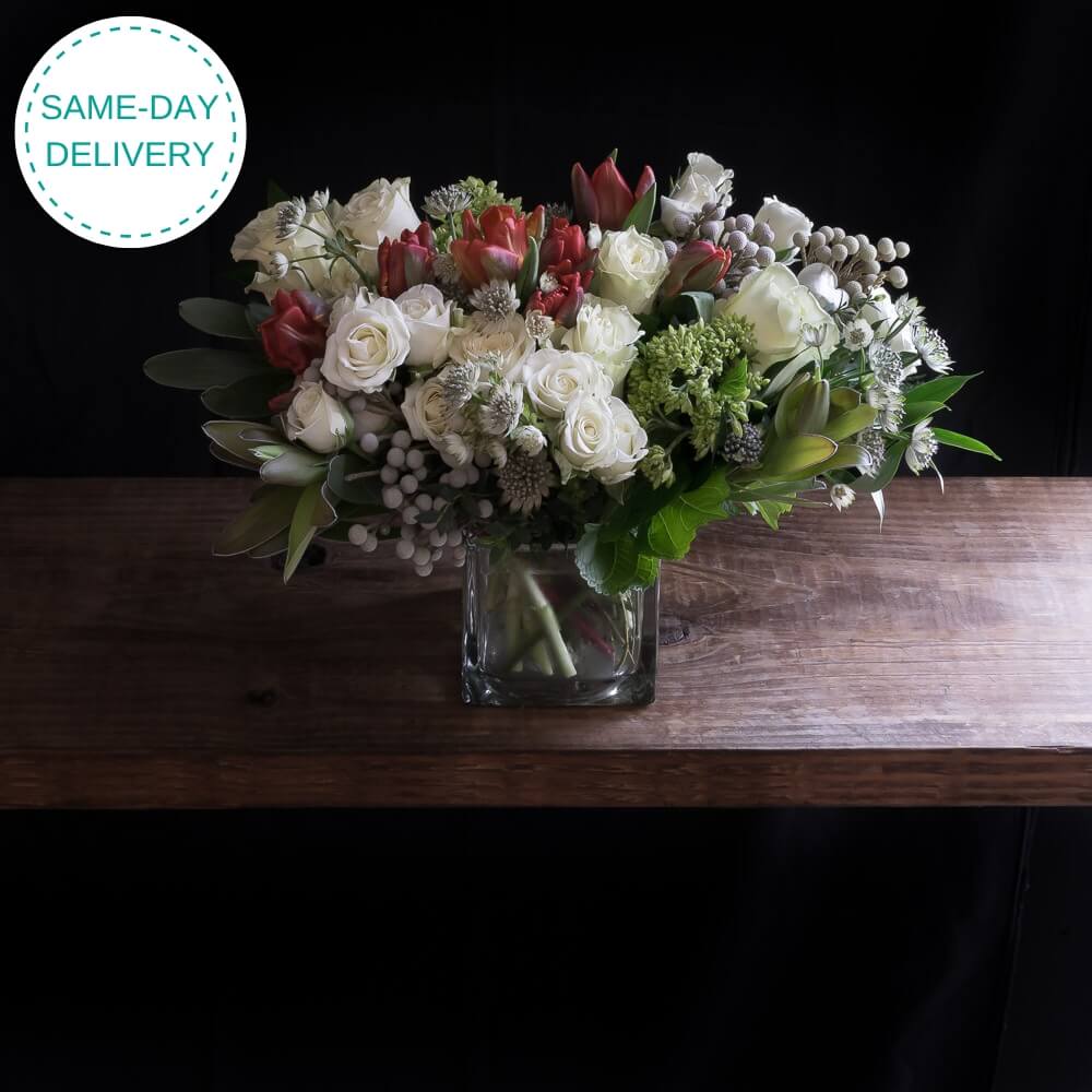 Jardin boutique floral arrangement for holiday, Christmas, with white roses, red tulips.