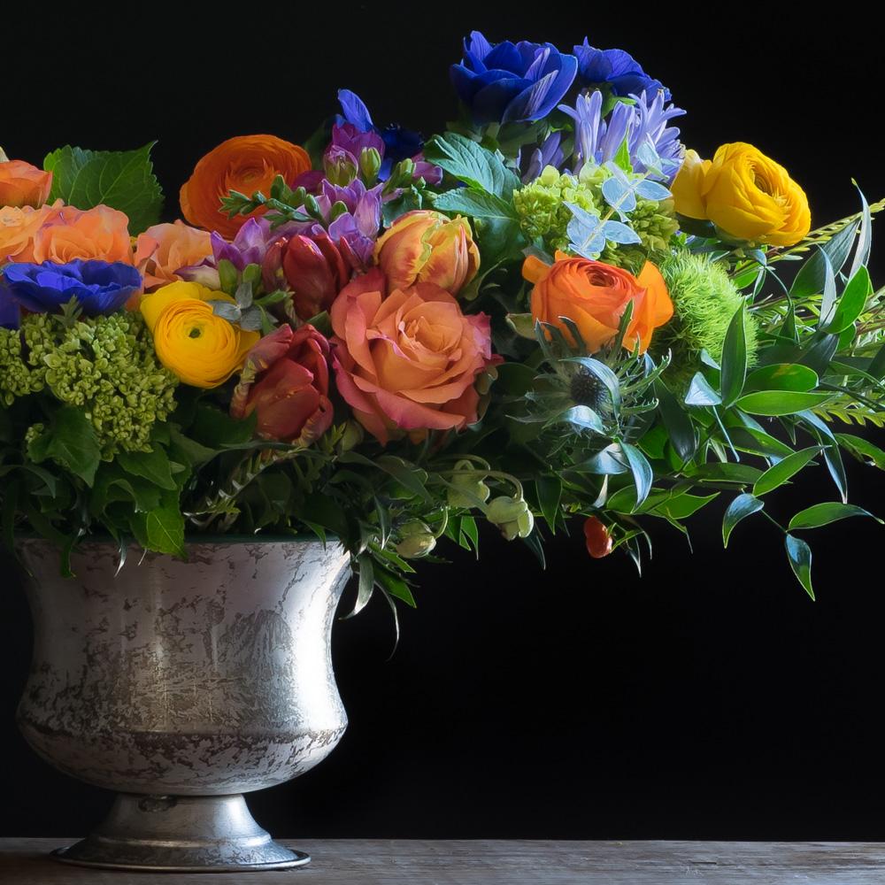 Beautiful flower arrangement with orange tulips, yellow flowers, pink roses and purple flowers