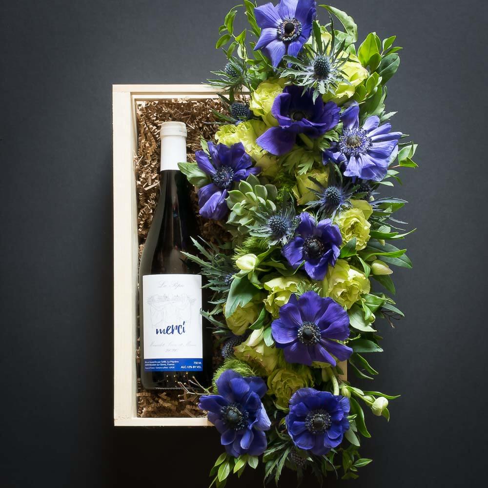 Floral Basket Gift Box boutique floral arrangemt with blue flowers, green roses and organic red sangiovese wine bottle