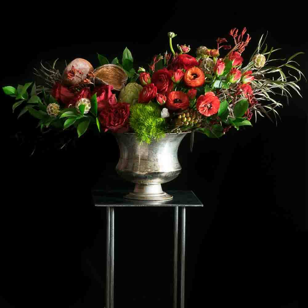 Luxury boutique floral arrangement of red flowers including red roses, red tulips, and red anemones