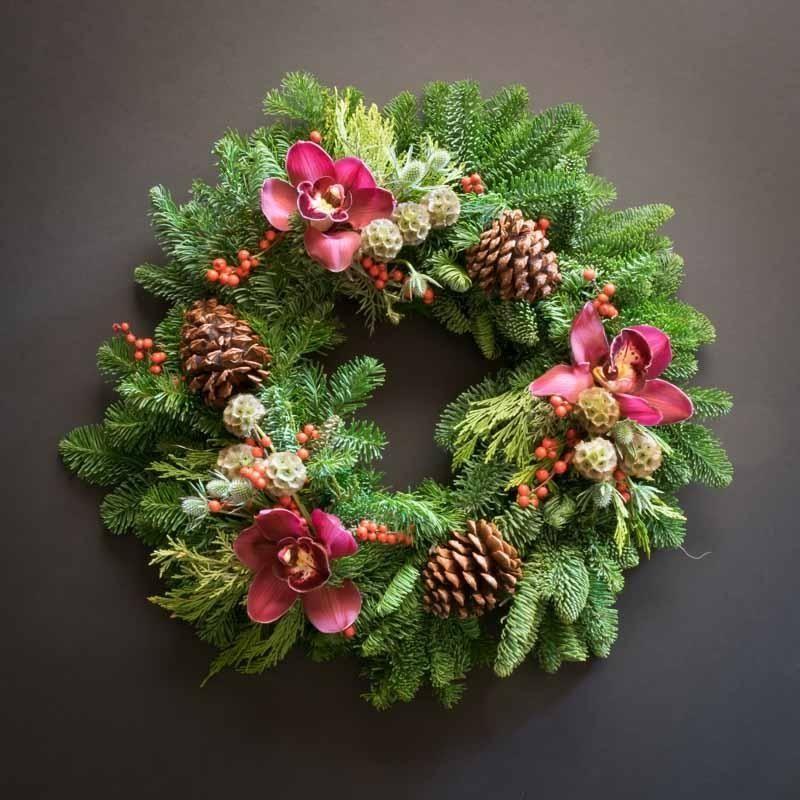 Christmas wreath with burgundy orchids, cones.