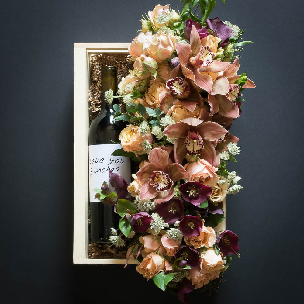 Floral Basket Gift Box with boutique floral arrangement of soft peach, orange colors and organic red sangiovese wine bottle