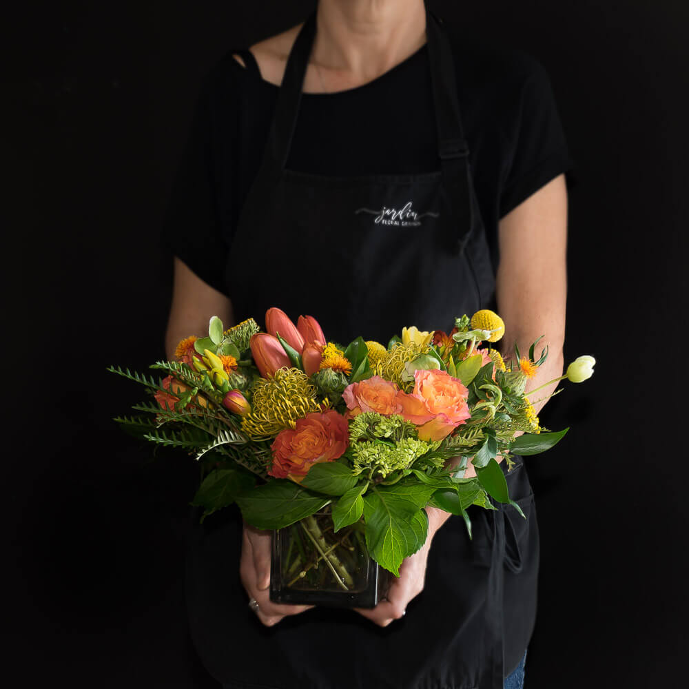 Beautiful unique boutique floral design of orange garden roses, yellow tulips, and orange tulips