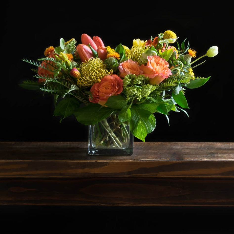 Beautiful unique boutique floral design of orange garden roses, yellow tulips, and orange tulips