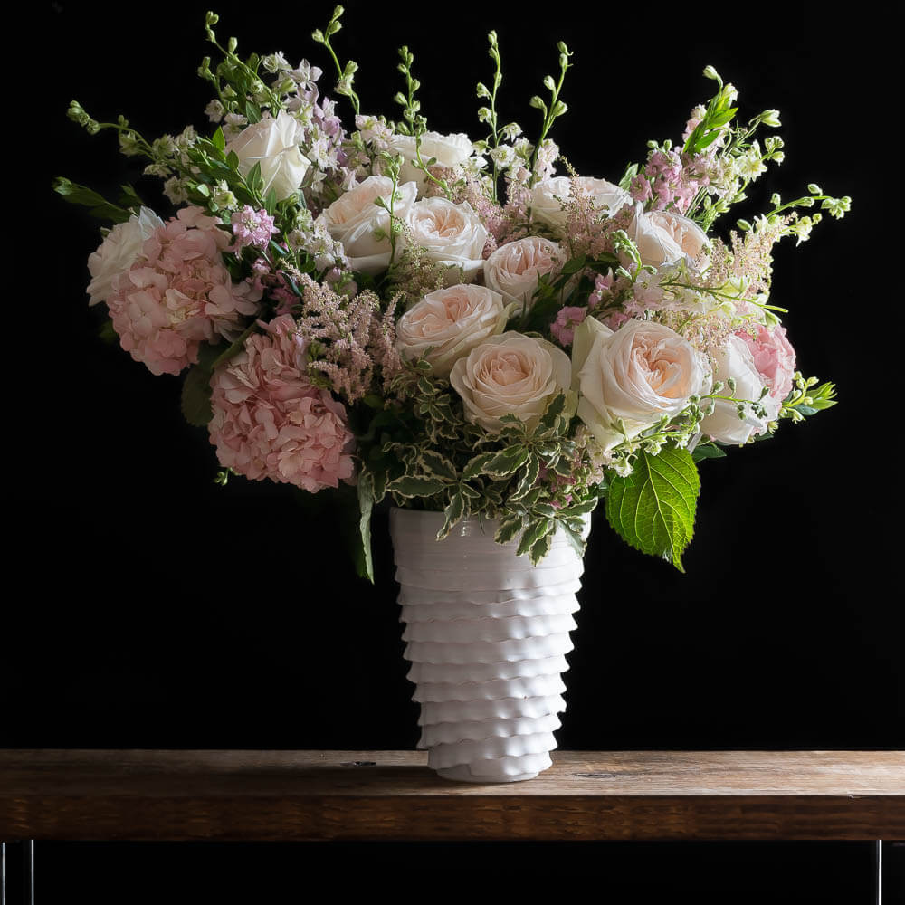 Unique boutique floral arrangement with soft pink roses, soft pink hydrangeas and white roses