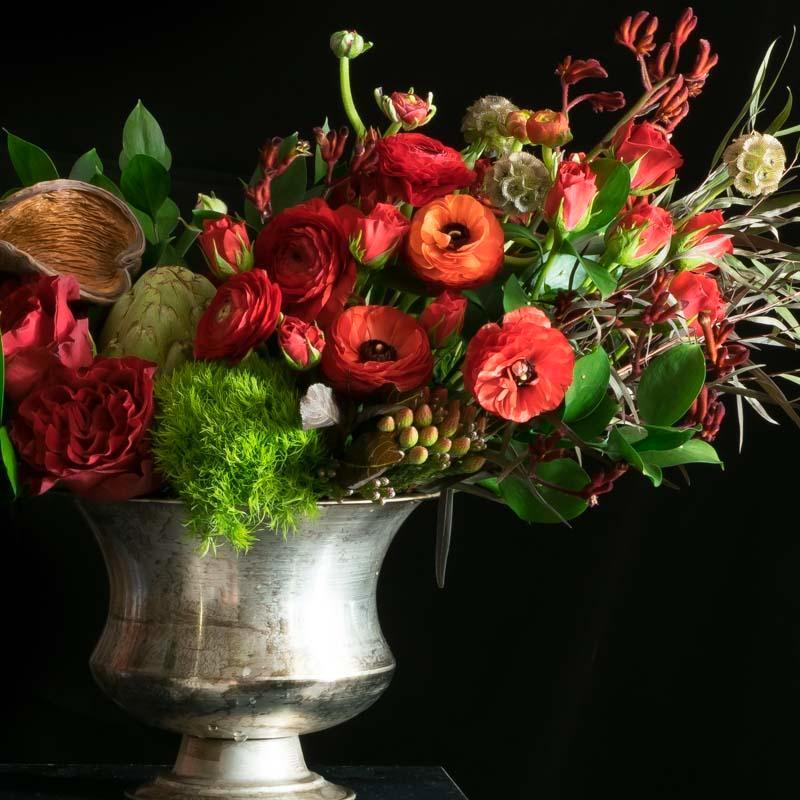 Large flower arrangement of red flowers including red roses, red tulips, and red anemones